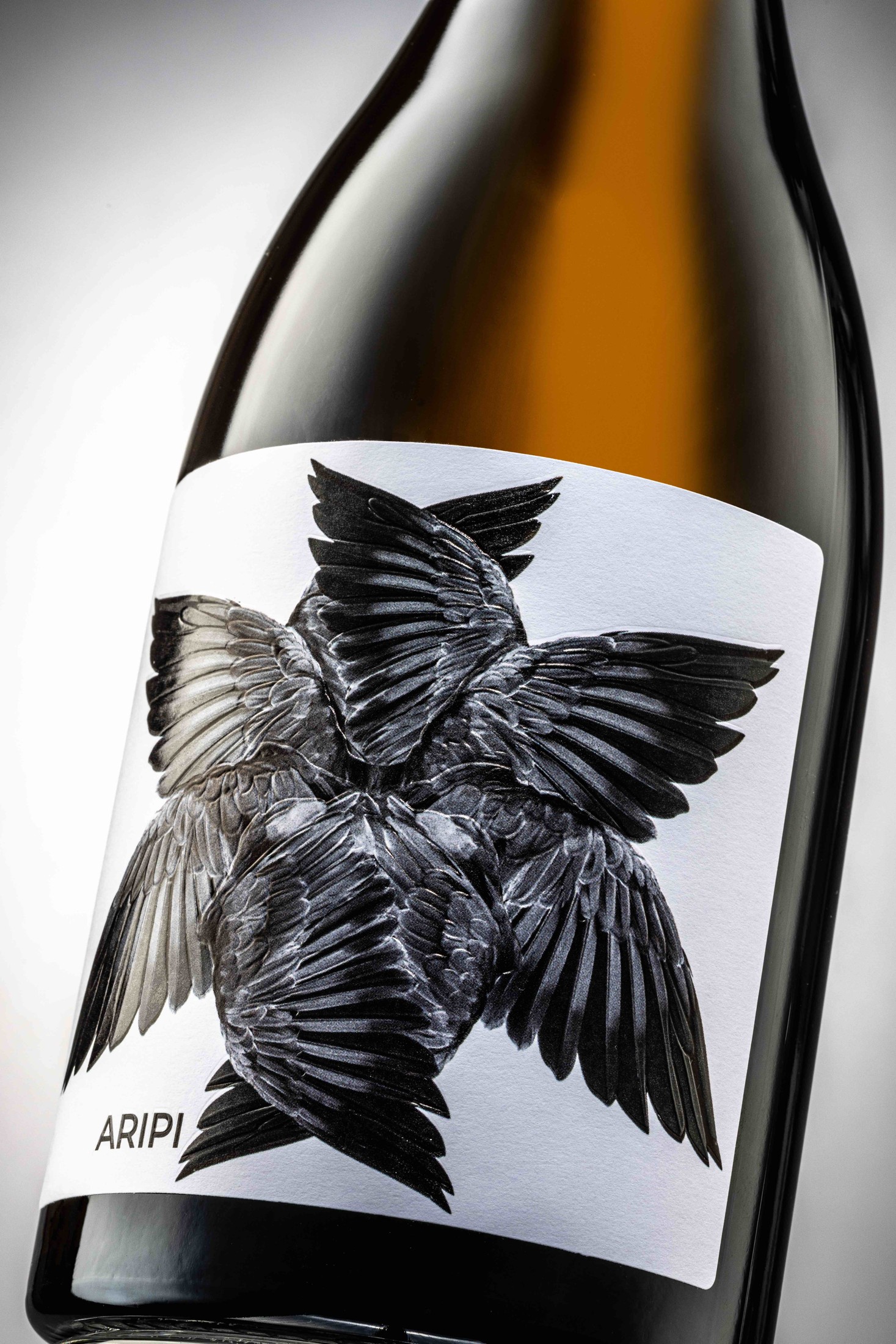 Aripi — etichetă cu aripi negre pe sticla de vin alb